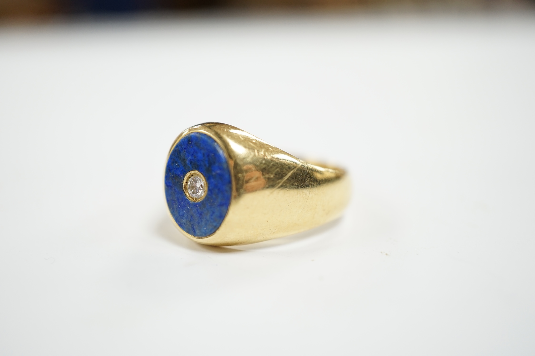 A mid to late 20th century Italian 750 yellow metal and oval lapis lazuli set signet ring, with inset diamond, size U, gross weight 12 grams.